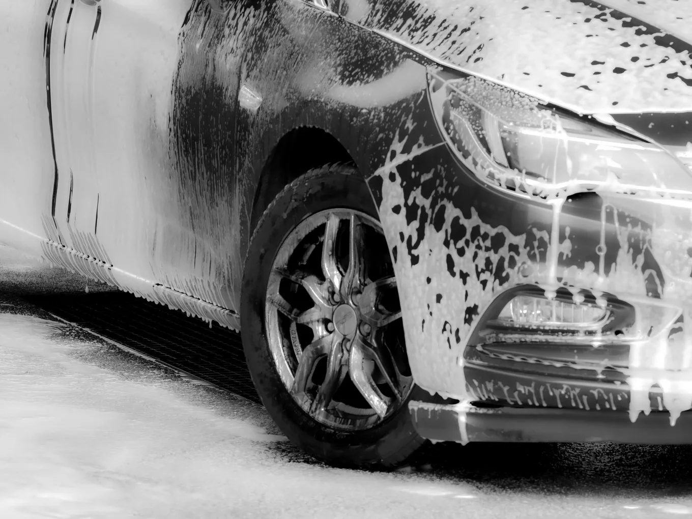 Foam covering a wheel and body panel during a decontamination wash