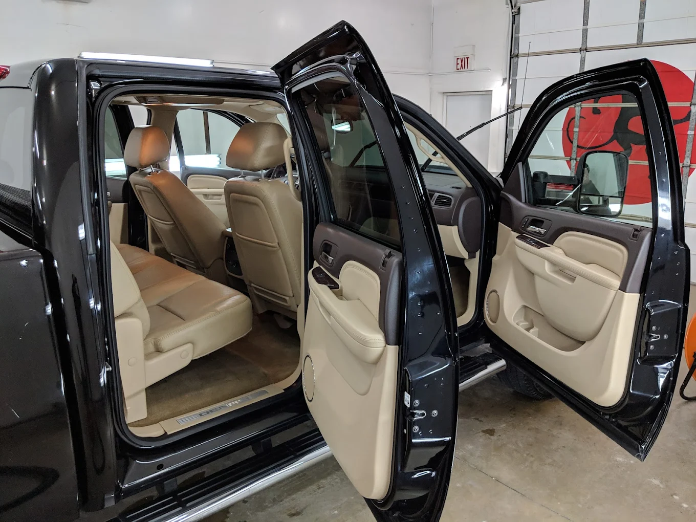 Clean tan leather rear seats with both doors open inside the detailing bay